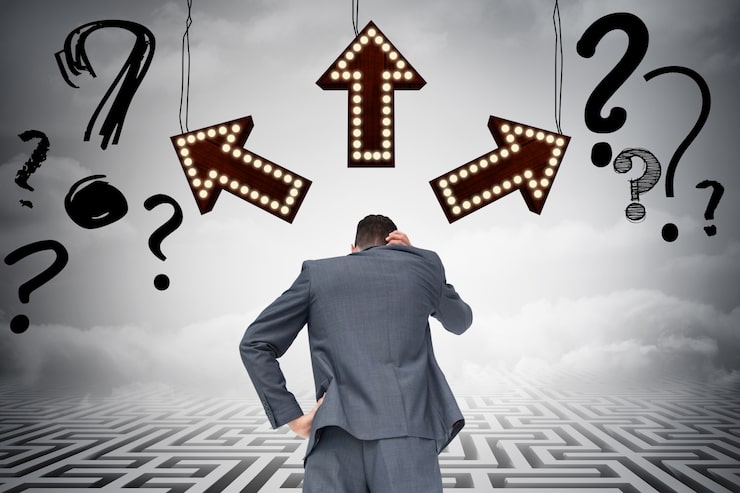 A businessman seen from behind, scratching his head, facing three arrows pointing in different directions and surrounded by question marks, illustrating the uncertainty of who makes the decision.